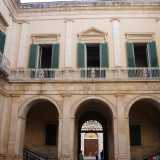 Superiamo il portale d�ingresso racchiuso tra due alte colonne e attraversiamo due semiportici con facciate ornate da lesene ritrovandoci nella corte interna quadrangolare